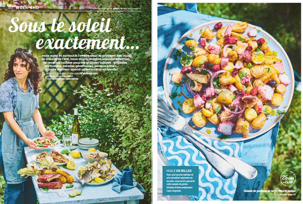 Une femme sert des plats colorés en extérieur, salade de légumes, ambiance estivale.